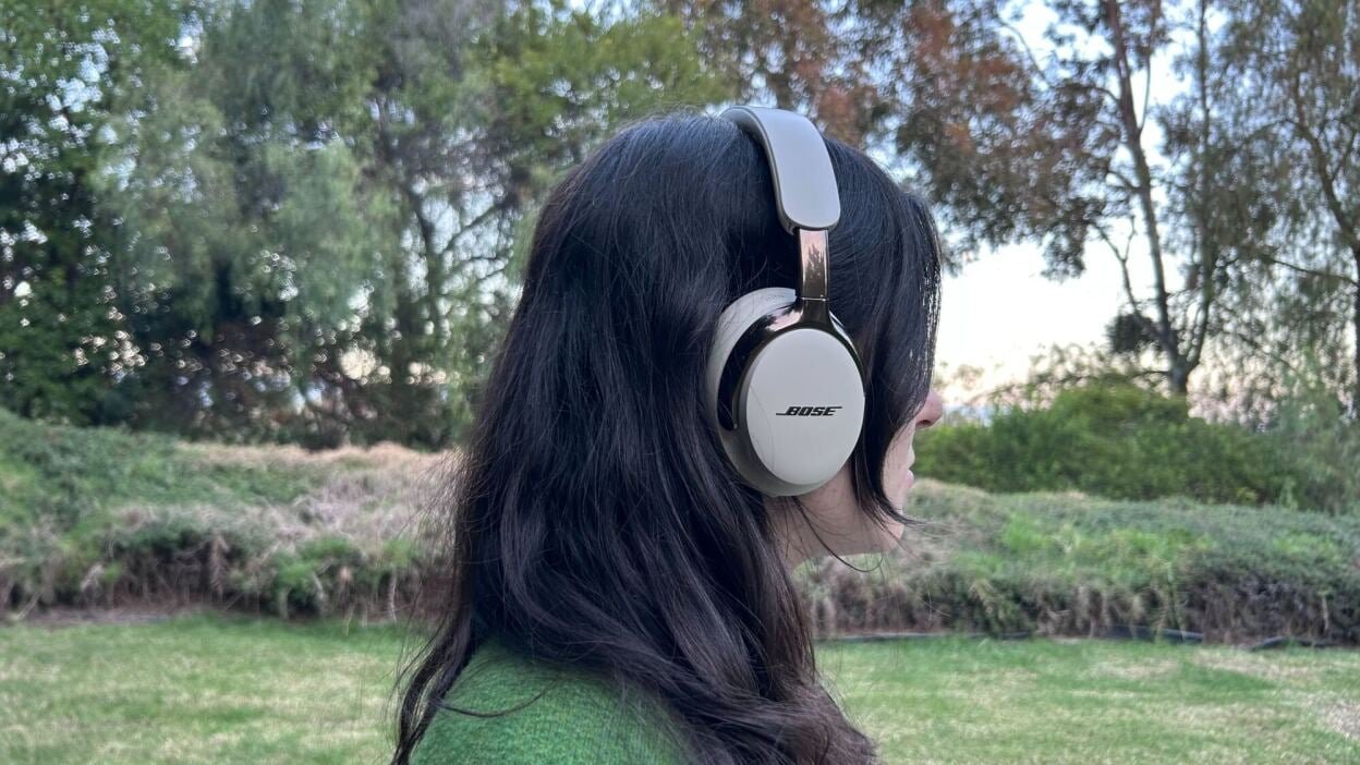 back view of woman with dark hair wearing Bose over-ear headphones