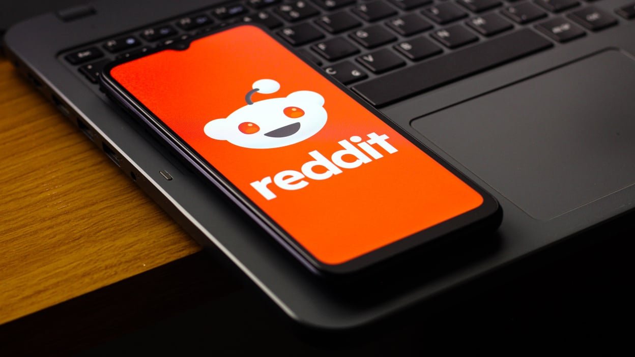 the Reddit logo is seen displayed on a smartphone screen