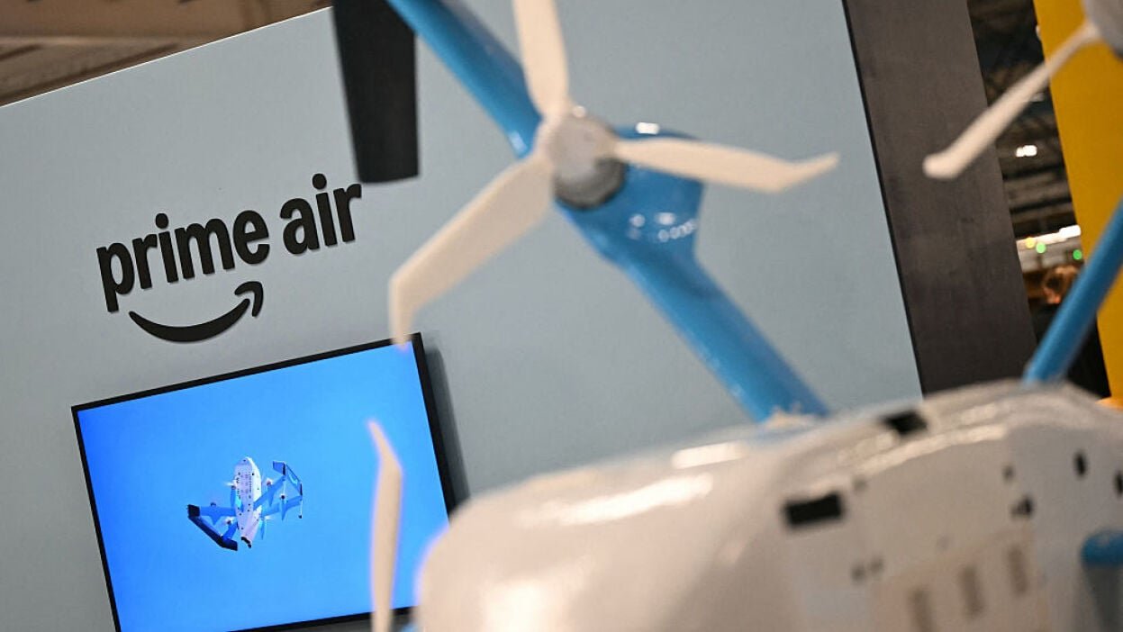 Amazon delivery drone in front of Prime Air logo