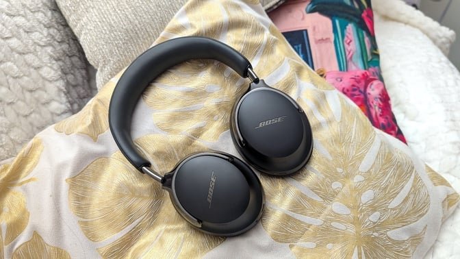 black pair of bose QC ultra headphones on a pillow